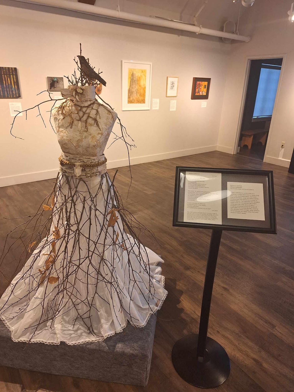 A mannequin in a room with a sign
Description automatically generated