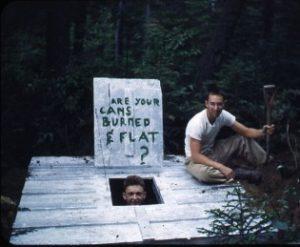 Two people posing in and out a trash pit