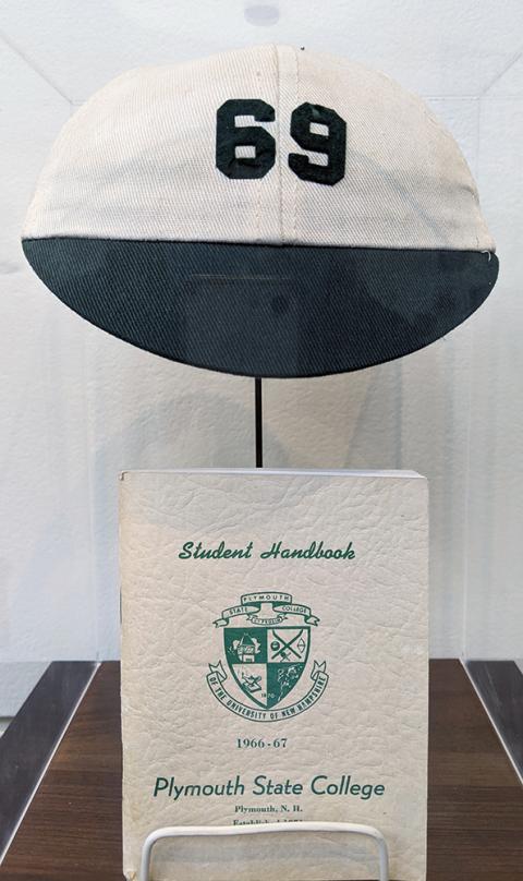 Plymouth State in 150 exhibition 1960s Freshamn beanie and book