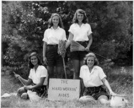 Four campers posing with brooms at Camp Onaway