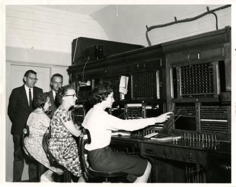 Photograph of people operating switchboard.