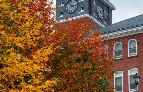 The tower of Rounds Hall peeks out from behind beautiful fall foliage on Plymouth State University's campus.