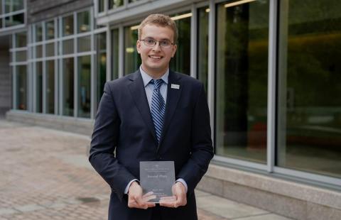 Photo of a young man, Kyle Dimick, holding a small award plaque.