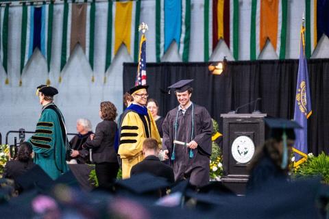 Undergrad student receives their degree on stage
